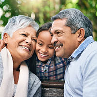 Grandparents hugging granddaughter